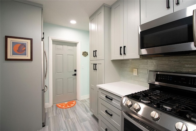 kitchen featuring baseboards, recessed lighting, stainless steel appliances, light countertops, and tasteful backsplash