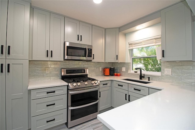 kitchen featuring a sink, appliances with stainless steel finishes, and gray cabinets