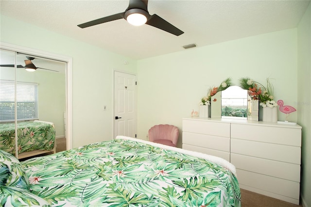 carpeted bedroom with multiple windows, visible vents, a closet, and ceiling fan