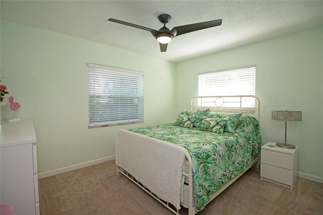 carpeted bedroom with baseboards, a textured ceiling, and ceiling fan