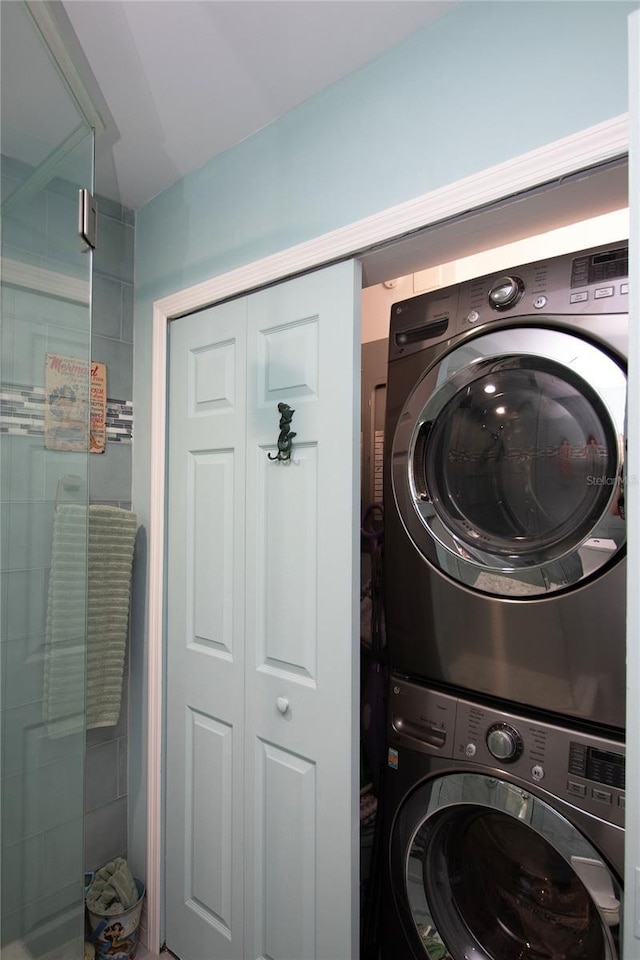 washroom with stacked washer and dryer and laundry area