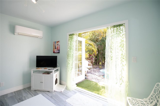 interior space with baseboards and a wall unit AC