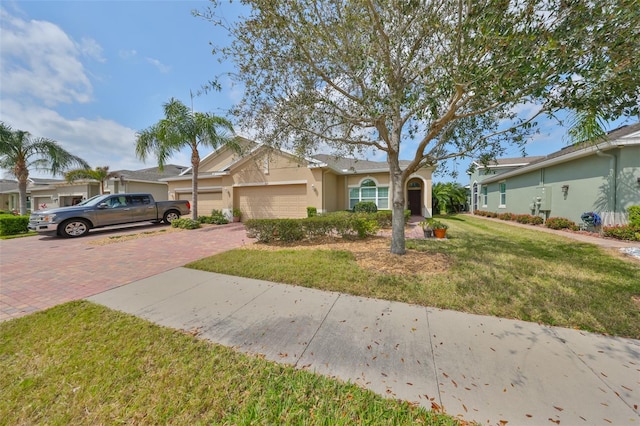 807 Chipper Dr, Sun City Center, FL 33573 - single story home featuring decorative driveway, a front yard, an attached garage, and stucco siding