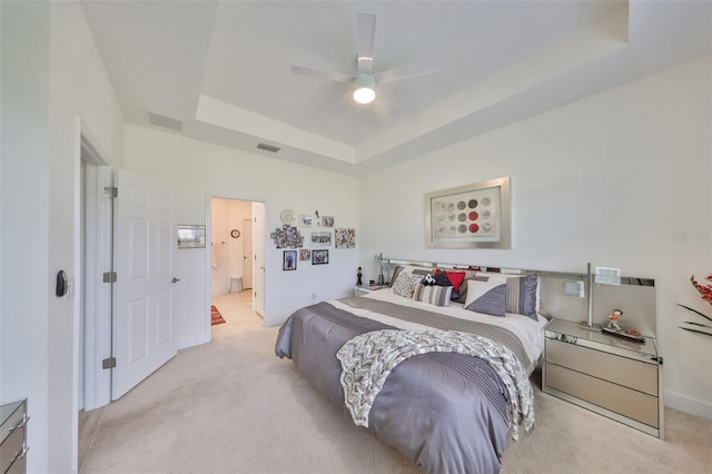 807 Chipper Dr, Sun City Center, FL 33573 - bedroom featuring visible vents, connected bathroom, carpet, and a tray ceiling