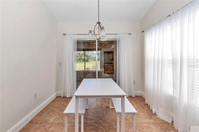 dining space featuring light tile patterned floors, baseboards, a notable chandelier, and a textured ceiling