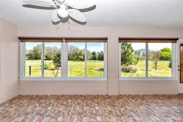 spare room featuring a textured ceiling and a ceiling fan