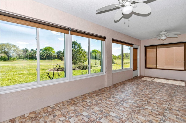 unfurnished sunroom with a ceiling fan