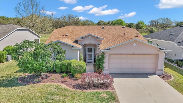 view of front of home featuring a front lawn, a garage, driveway, and stucco siding