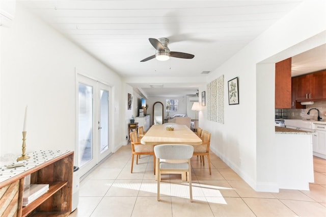 dining area with light tile patterned floors, baseboards, and ceiling fan