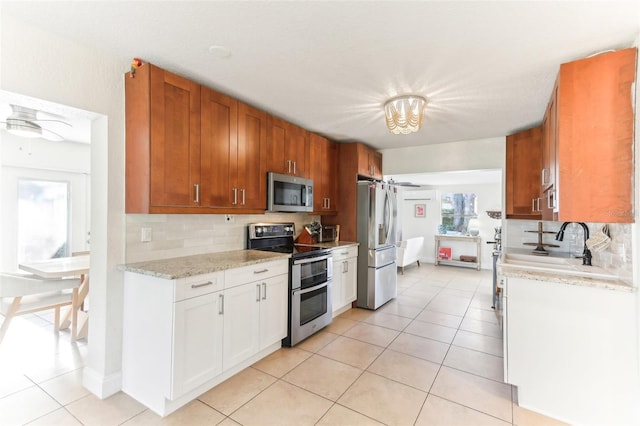 kitchen with light tile patterned floors, decorative backsplash, and appliances with stainless steel finishes