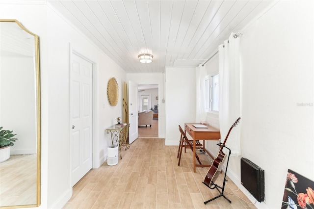 hallway with heating unit, wood ceiling, baseboards, and light wood finished floors