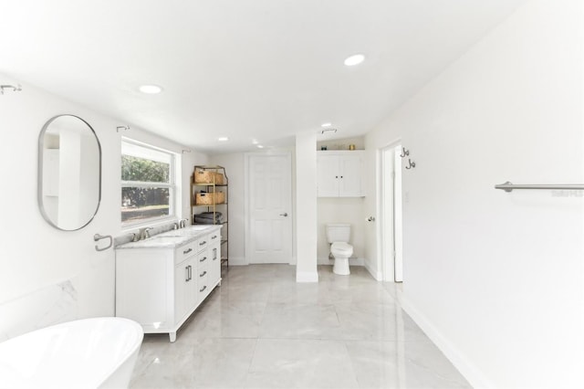 bathroom with toilet, recessed lighting, baseboards, a freestanding bath, and vanity