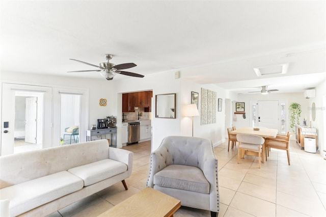 living room with an AC wall unit, attic access, light tile patterned floors, and a ceiling fan