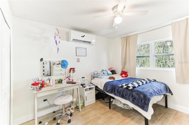 bedroom featuring wood finish floors, baseboards, a ceiling fan, and a wall mounted AC