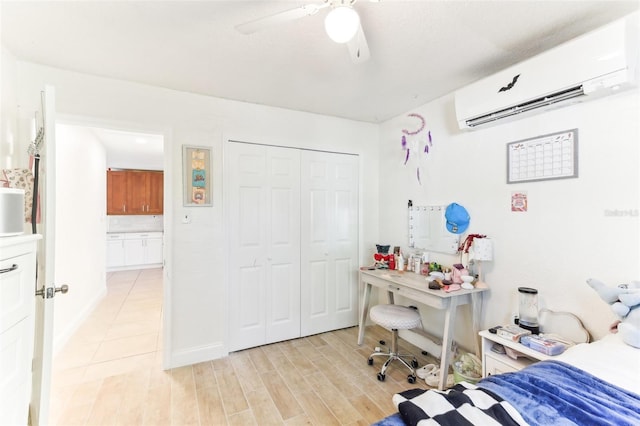 bedroom featuring an AC wall unit, a ceiling fan, a closet, and light wood-type flooring