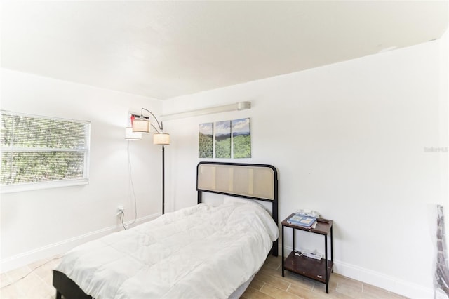 bedroom featuring baseboards and wood tiled floor