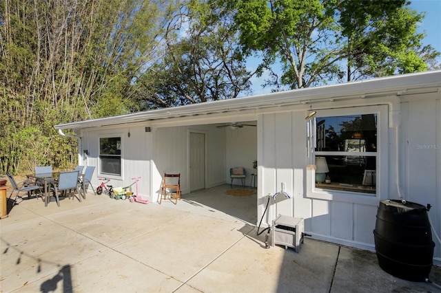 back of house featuring a carport, outdoor dining space, and a patio area