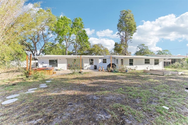 view of front of house with a jacuzzi, a patio, and an attached carport