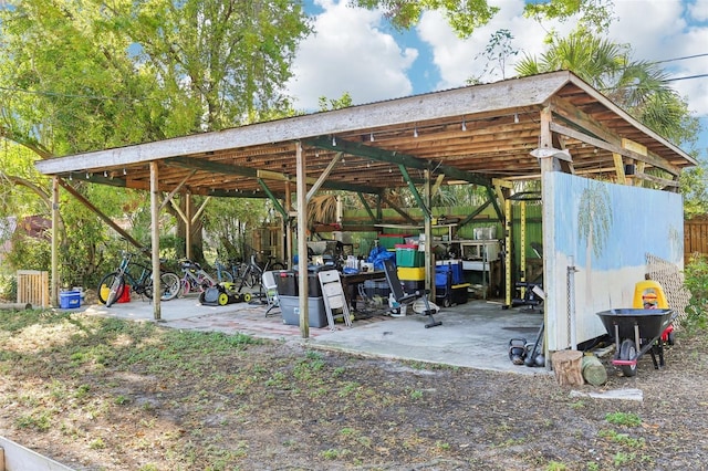 view of patio / terrace featuring a detached carport and an outbuilding