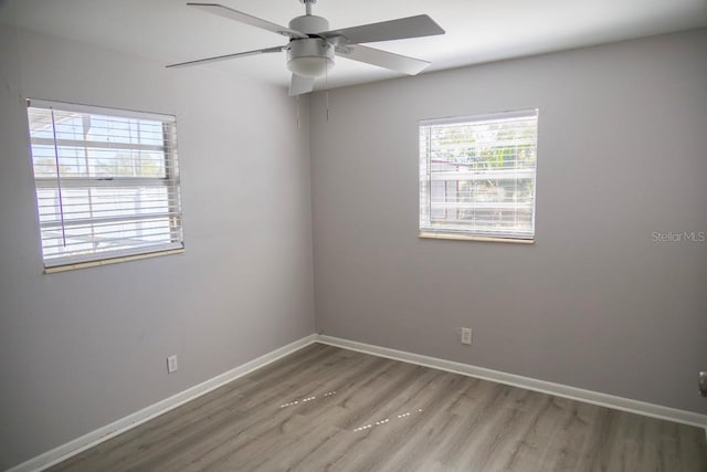 unfurnished room featuring baseboards, wood finished floors, and a ceiling fan