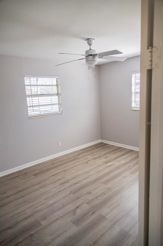 unfurnished room with a ceiling fan, baseboards, and wood finished floors