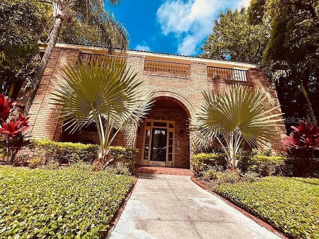 doorway to property featuring brick siding