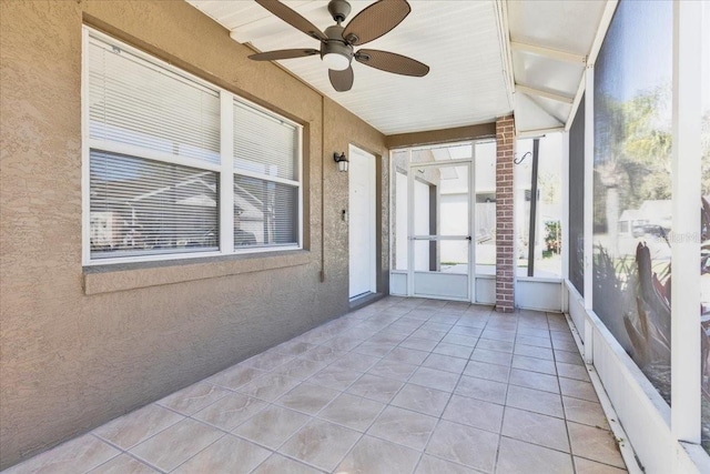 unfurnished sunroom featuring ceiling fan