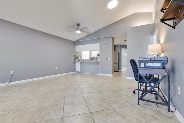 home office featuring vaulted ceiling, light tile patterned flooring, a ceiling fan, and baseboards