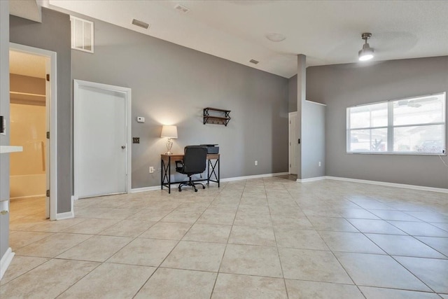 office space featuring lofted ceiling, light tile patterned flooring, baseboards, and visible vents