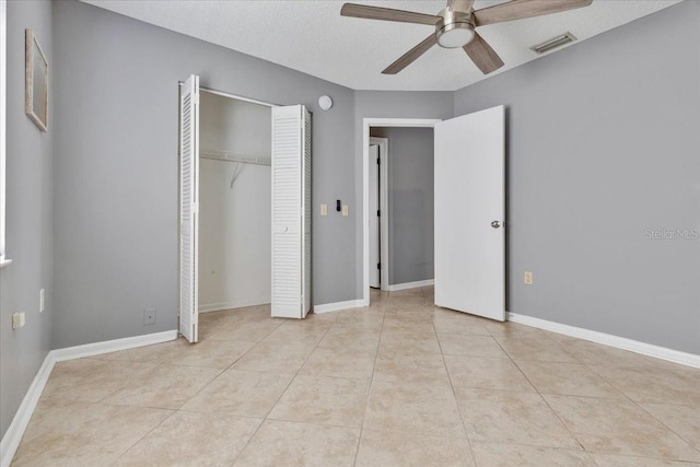 unfurnished bedroom with light tile patterned flooring, baseboards, visible vents, and a closet