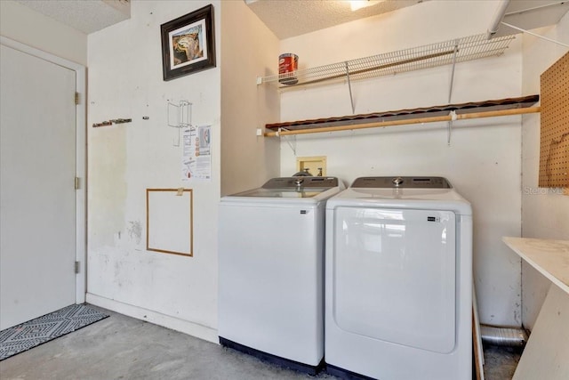 washroom featuring laundry area, independent washer and dryer, and a textured ceiling