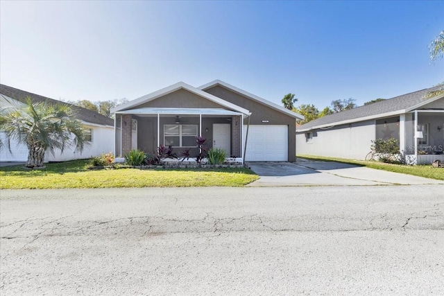 view of front of property featuring a front yard, an attached garage, driveway, and stucco siding