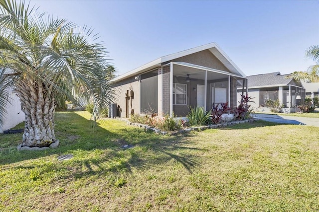 view of side of home with a garage, a yard, and a sunroom