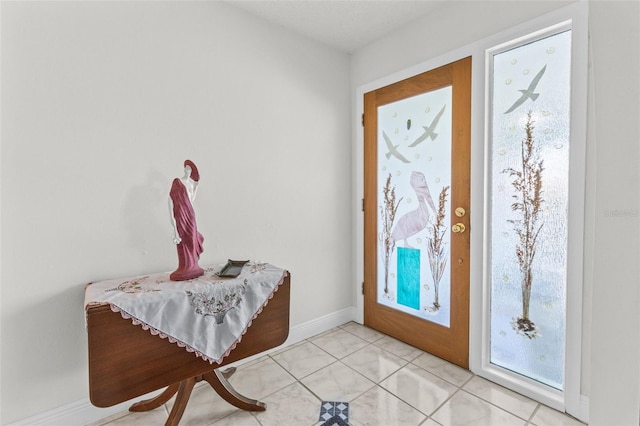 foyer entrance with light tile patterned flooring and baseboards