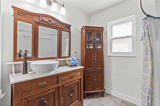 full bath featuring tile patterned flooring, vanity, a shower with shower curtain, and baseboards