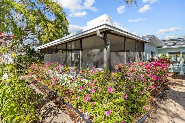 view of property exterior with stucco siding and a sunroom