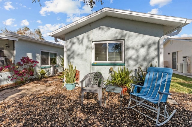 rear view of property featuring stucco siding