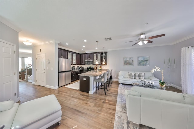 living area featuring crown molding, light wood-style flooring, and visible vents