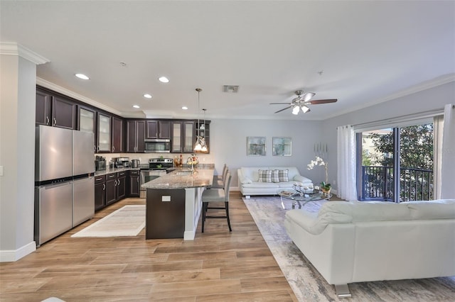 kitchen featuring visible vents, dark brown cabinets, crown molding, open floor plan, and appliances with stainless steel finishes