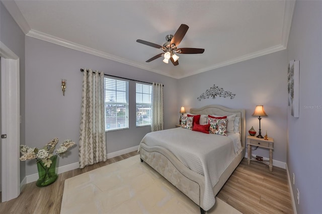 bedroom featuring baseboards, wood finished floors, and ornamental molding