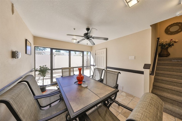 dining space with stairway, a textured ceiling, and ceiling fan