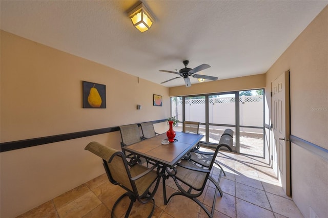 dining room with stone tile flooring, a textured ceiling, and ceiling fan