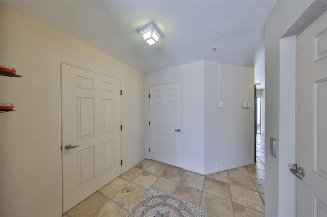 foyer entrance featuring a textured ceiling