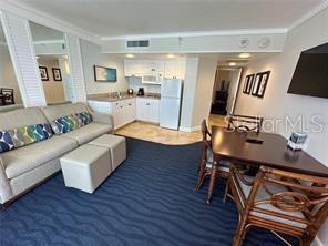 living room with visible vents and ornamental molding