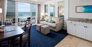 living room featuring a beach view, floor to ceiling windows, and a water view