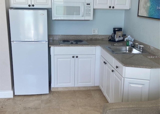 kitchen featuring white cabinetry, white appliances, and a sink