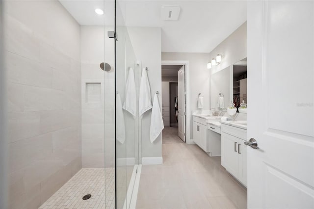 bathroom featuring vanity, baseboards, and tiled shower