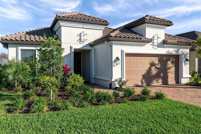 mediterranean / spanish-style house featuring a garage, decorative driveway, stucco siding, and a tiled roof