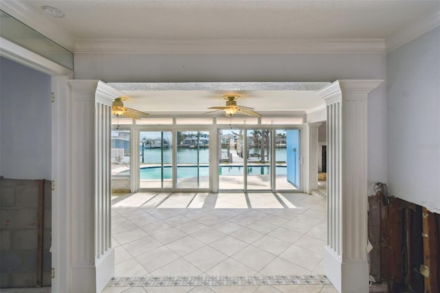 empty room featuring light tile patterned floors, ornamental molding, and a ceiling fan