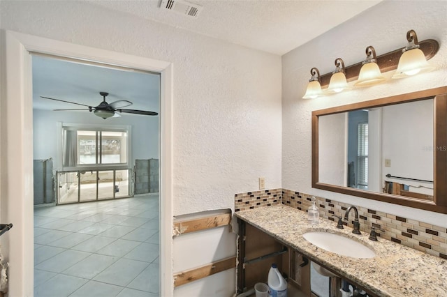 bathroom with a sink, visible vents, and a textured wall